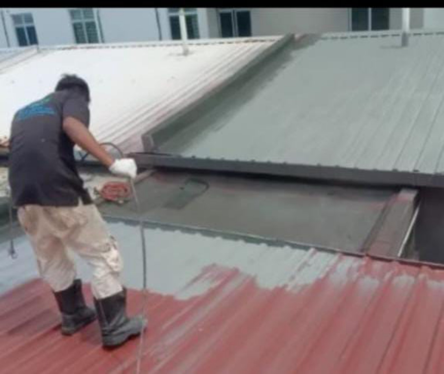 Protective coating application on a metal roof.