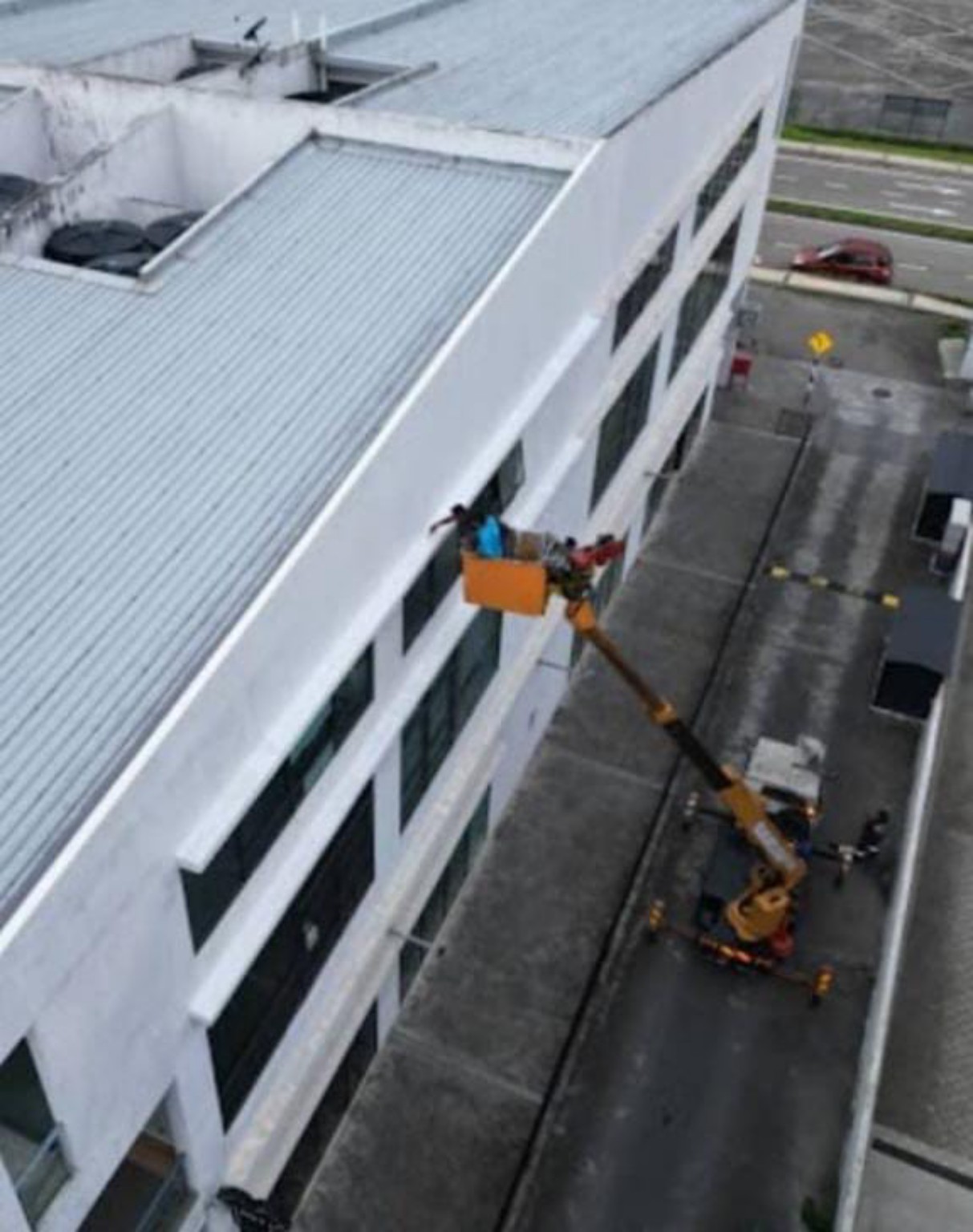External wall crack treatment to address water seepage, accessed using a boom lift.